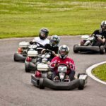 Groupe de karts colorés pilotés en compétition loisir sur circuit fermé