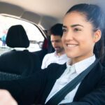 femme souriante au volant, passager à l'arrière, ceinture de sécurité