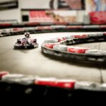 Un kart miniature tourne rapidement sur une piste indoor sinueuse