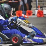 Un conducteur en combinaison bleue pilote un kart bleu sur piste